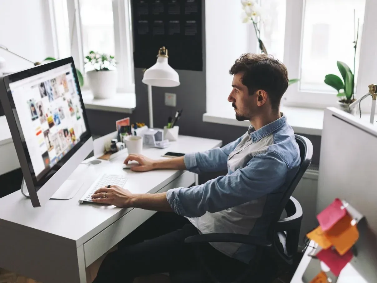 Profissional trabalhando no site da empresa em um iMac
